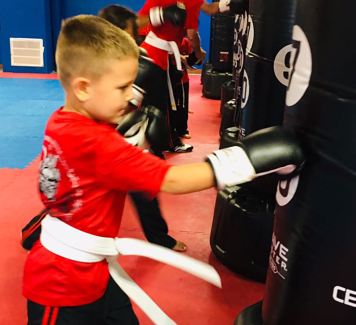 young boy punching bag at Orlando Karate School