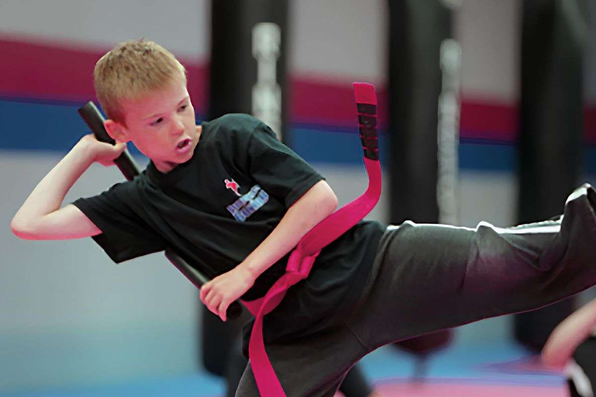 teen kicking pad in martial arts school