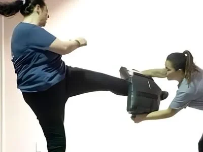 adult female kicking pad in martial arts school in Orlando